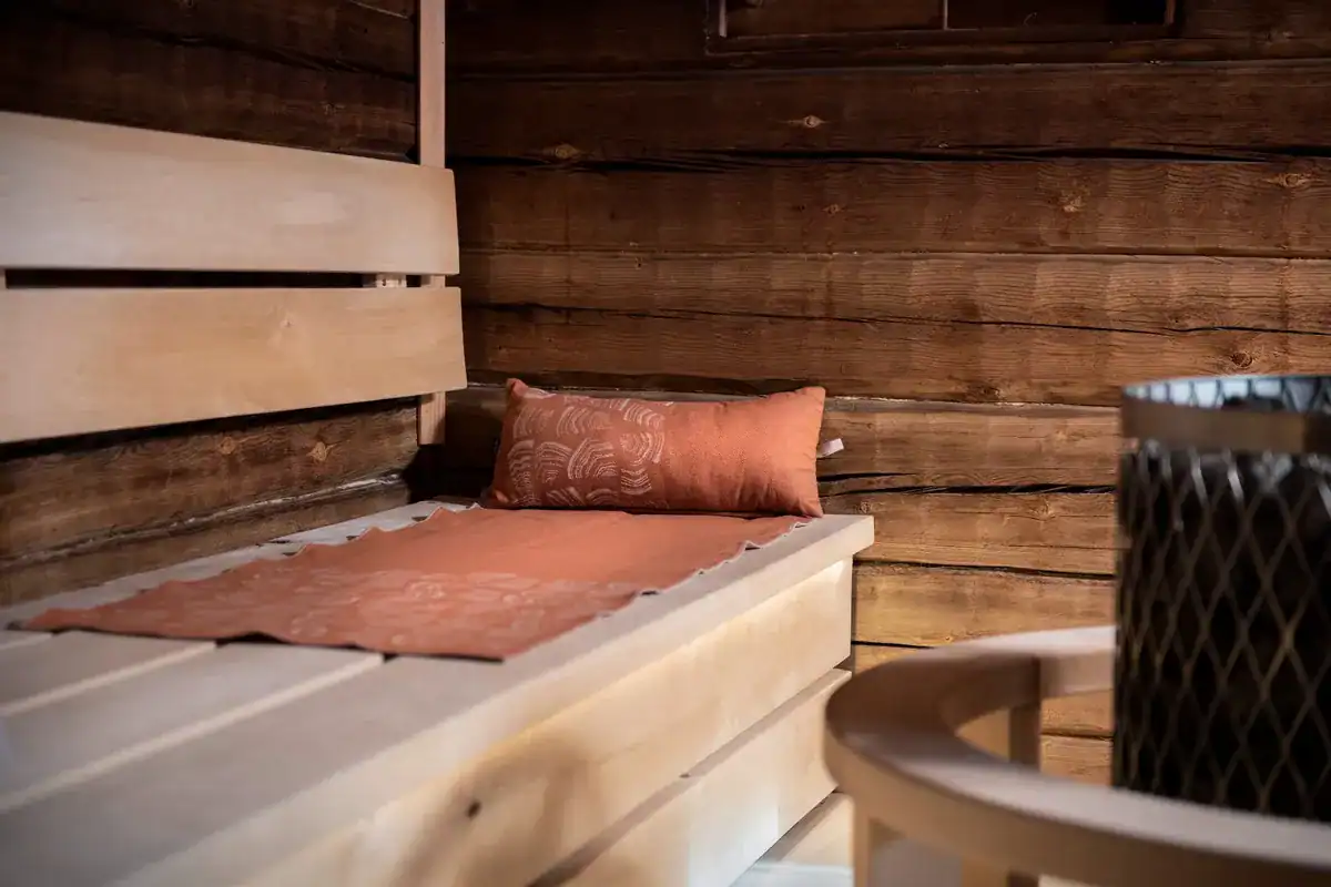 Coussin de sauna Rento Pino marron sur un banc en bois dans un sauna.