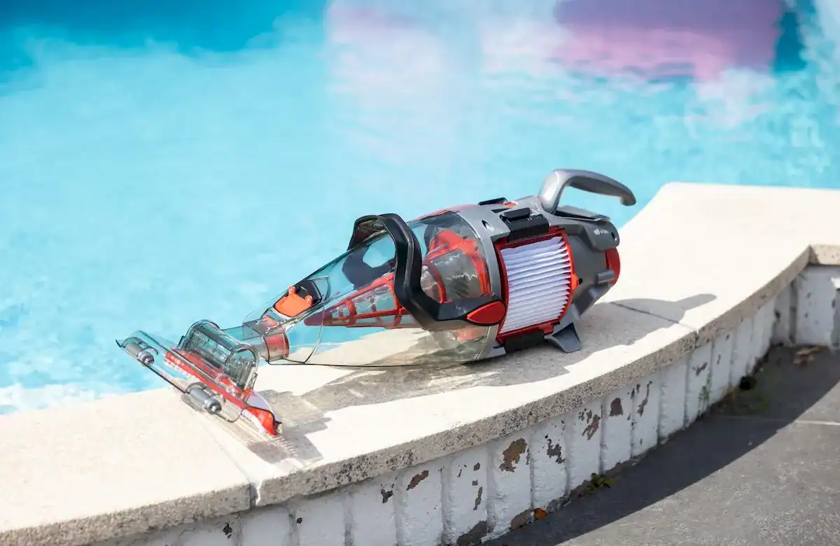 Aspirateur de piscine électrique au bord de la piscine pour le nettoyage.