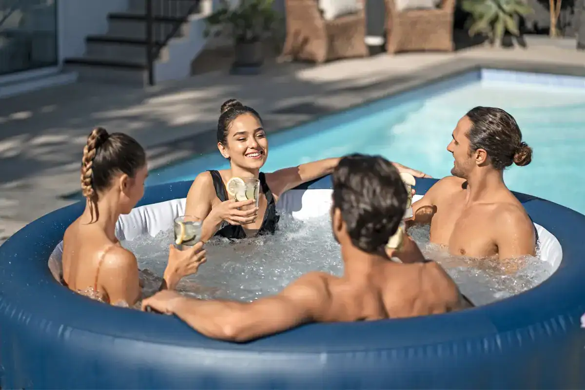 Un groupe de personnes profite du Lay-Z Spa Milan Airjet Plus dans le jardin.