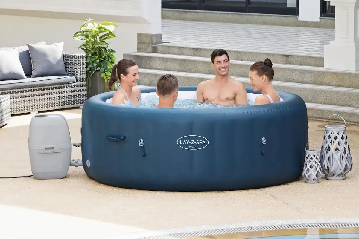 Des familles profitent du spa extérieur Lay-Z Spa Milan Airjet Plus pour 6 personnes.