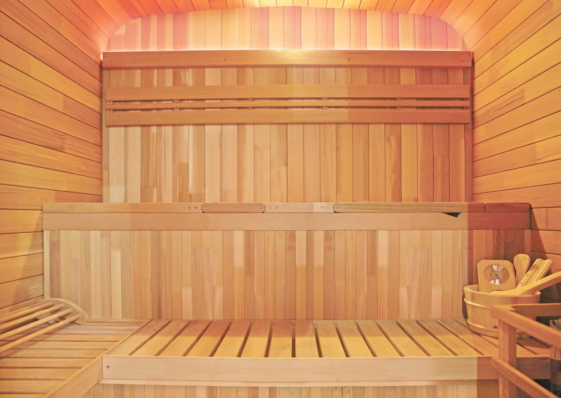 Sauna extérieur en bois d'épicéa avec bancs et accessoires.