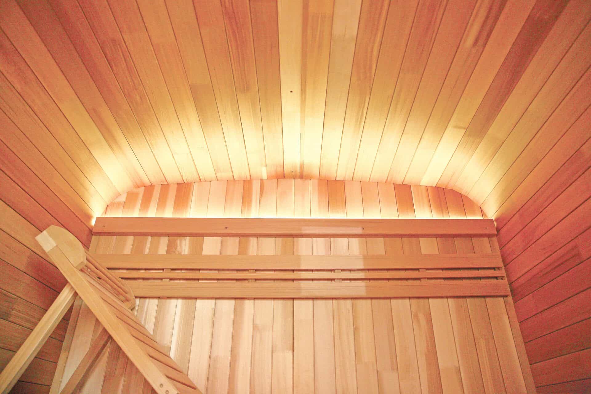 Sauna extérieur en bois avec intérieur en bois et éclairage d'ambiance.