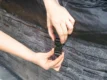 Main fixant une bâche de piscine à l'aide d'une fermeture à clic.