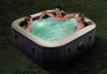 Des familles profitent d'un jacuzzi gonflable dans le jardin.
