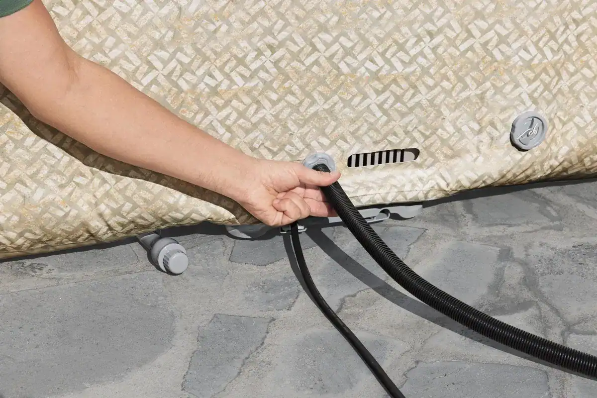 Main raccordant un tuyau d'eau au Lay-Z Spa Rome EnergySense Airjet.