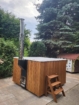 Hot tub avec extérieur en bois et évacuation de vapeur, adapté à la détente au jardin.