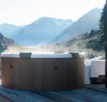 Rova frame spa pour 6 personnes sur une terrasse avec paysage montagneux.