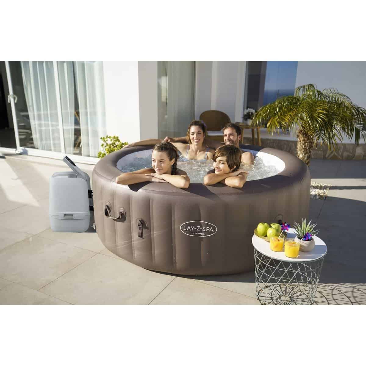Jacuzzi gonflable avec quatre personnes, idéal pour la détente et le plaisir dans le jardin.