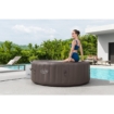 Piscine gonflable avec une femme assise à l'intérieur, idéale pour le plaisir au jardin.